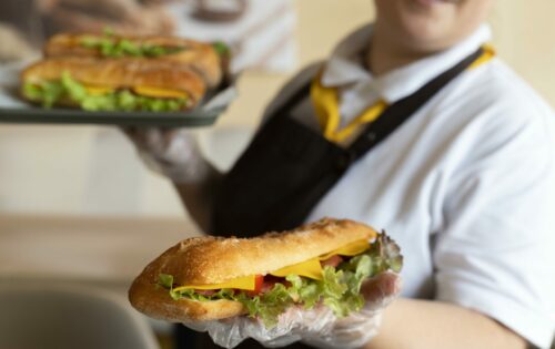 close-up-young-chef-holding-sandwiches